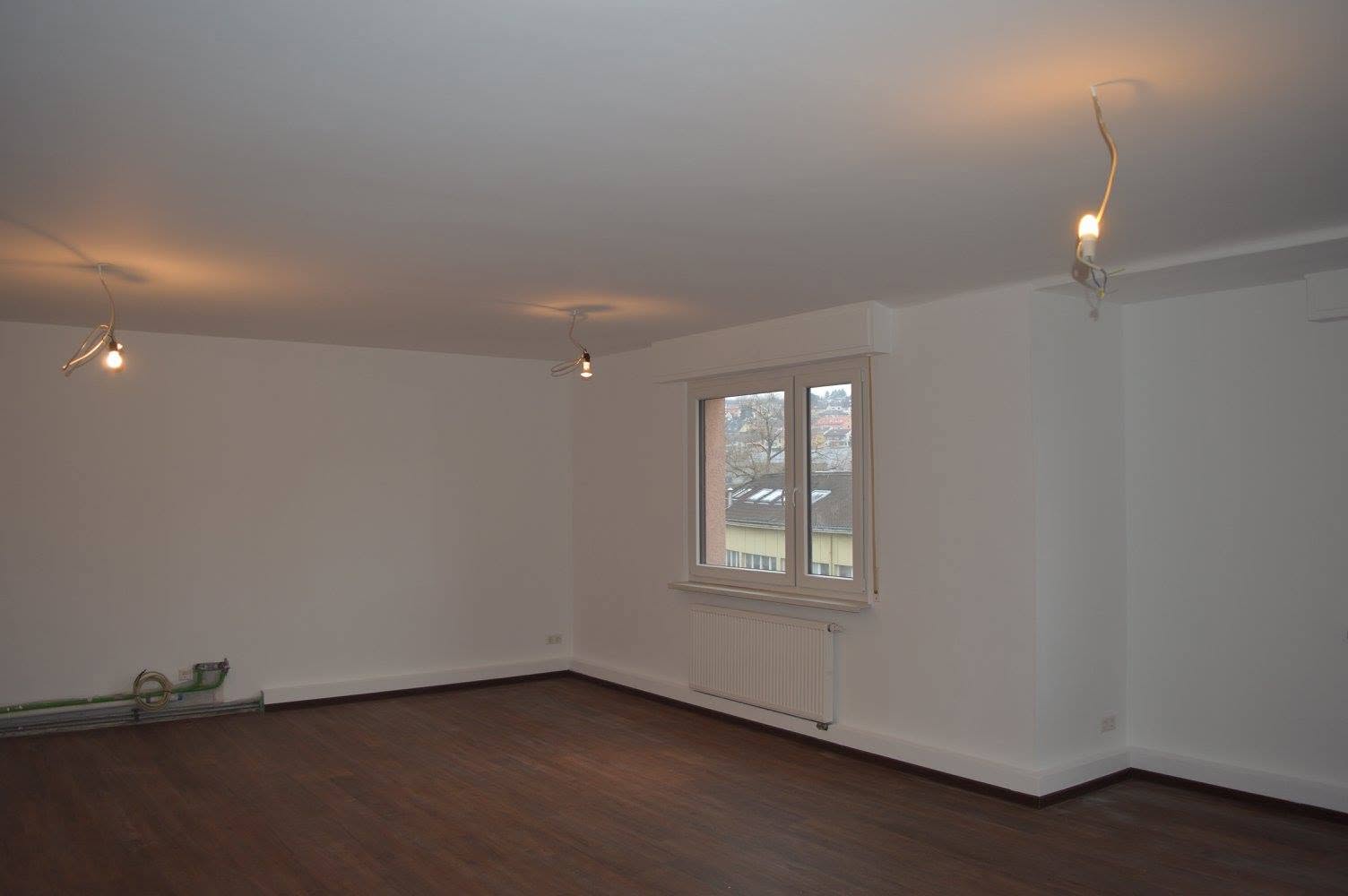 Wohnzimmer in Reinweiß mit Nussbaum-Parkett